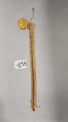 gros plan d'une chaîne en or sur laquelle se trouve une pièce de monnaie