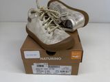 une paire de chaussures pour bébé dans une boîte posée sur une surface blanche