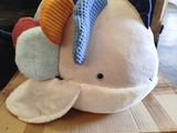 a stuffed whale sitting on top of a cardboard box