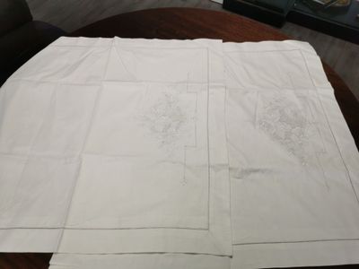 une nappe blanche ornée d'un motif, posée sur une table en bois