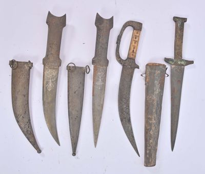 several old knives are lined up on a white surface