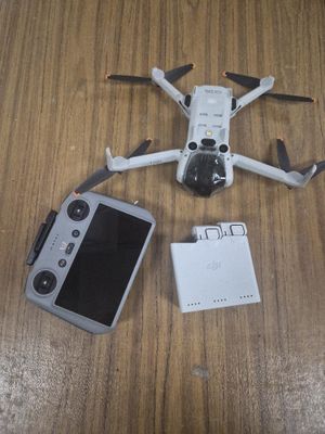 une télécommande, un téléphone portable et une télécommande posée sur une table
