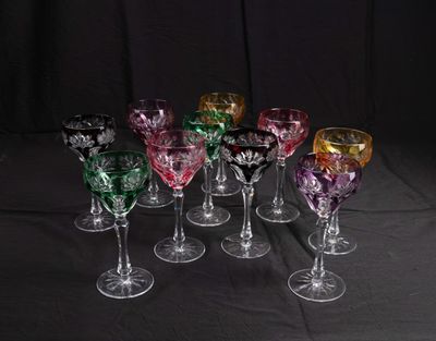 six different colored wine glasses sitting on top of a black table