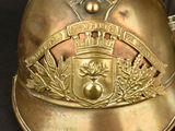 a gold helmet with a crest on it on a black surface