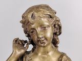 bronze statue of a young girl holding a flower in her right hand