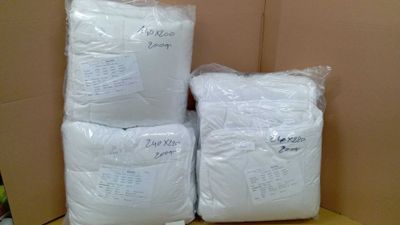 several bags of white pillows sitting on top of a cardboard box