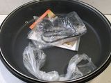 a black bowl with plastic bags in it on a counter