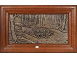 a bronze plaque depicting a boar and a boar in the woods