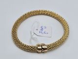 a gold bracelet with a clasp on a white background