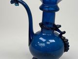 a blue glass vase with a flower on it