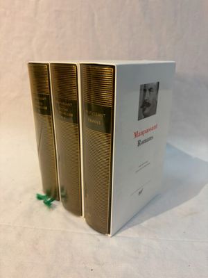 three books that are sitting on a white surface