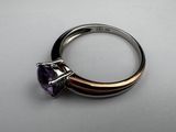 a close up of a ring with a purple stone on it