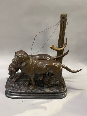 bronze statue of a dog with a bird in its mouth on a base