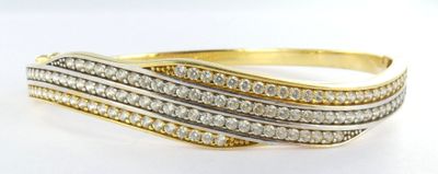 a close up of a gold and diamond ring on a white surface