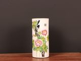 a vase with a bird on it sitting on a table