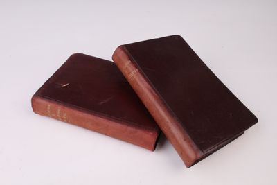 deux vieux livres posés l'un sur l'autre sur une surface blanche