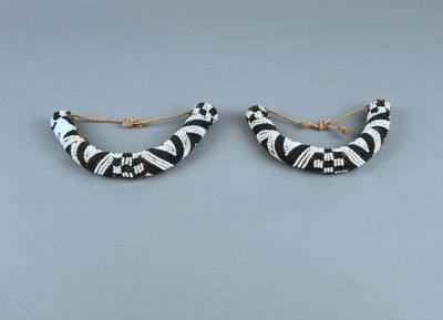 une paire de boucles d'oreilles en anneau rayées noir et blanc sur fond gris