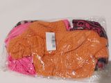 a bag of orange sweaters sitting on a table