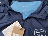 the jacket is blue and has a white nike logo on it