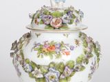 un vase blanc surmonté d'une figurine
