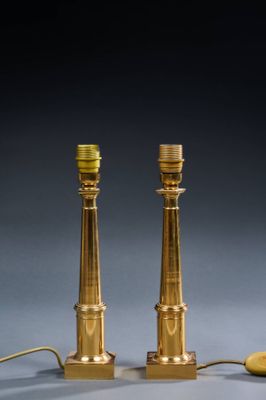 a pair of brass candles on a table next to a mouse