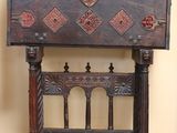a small wooden chest on a stand with a decorative design