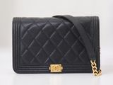 un sac Chanel noir muni d'une chaîne dorée sur fond blanc