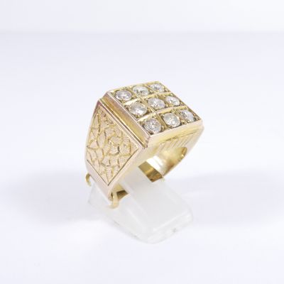 a close up of a gold ring with diamonds on a white surface