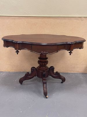 a small table with a wooden top on a gray floor
