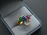 a ring in a ring box with a diamond and gems