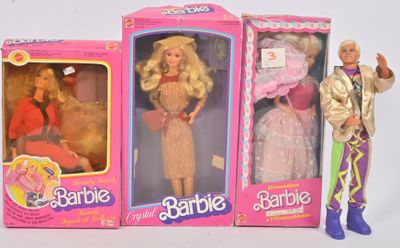 Trois poupées Barbie sont alignées les unes à côté des autres sur une surface blanche