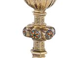 un calice en or et une assiette en argent sur fond blanc