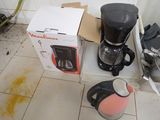 a box with a coffee maker and a kettle sitting on the floor