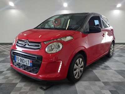 the small red car is parked in a large room