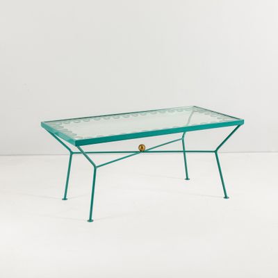 une table basse en verre avec une structure en métal et un plateau en verre