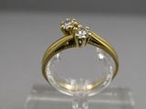 une image montrant un gros plan d'une bague en diamant posée sur une surface transparente