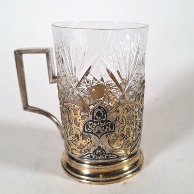 un verre à anse posé sur une surface blanche