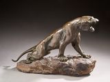 statue of a lion on a rock on a gray background