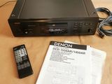 un lecteur DVD posé sur une table, avec une télécommande à côté