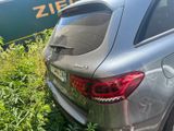 a silver car parked next to a train on the tracks