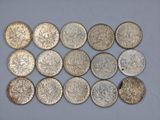 a bunch of silver coins sitting on top of a white surface