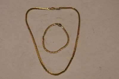a close up of a necklace and a bracelet on a table