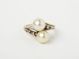 a white pearl and diamond ring on a white background