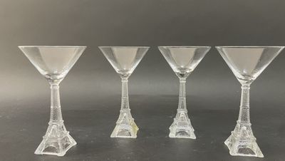 quatre verres à vin transparents posés les uns à côté des autres sur une table