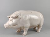 statue d'un cochon sur fond gris, avec un fond gris