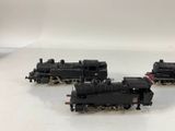 four black toy trains sitting on a white surface