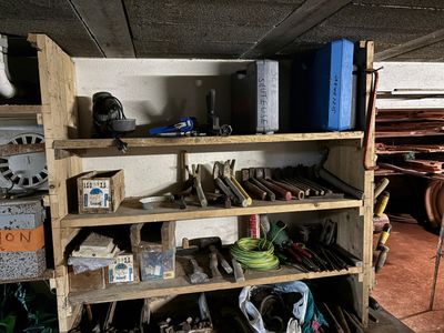 une étagère remplie d'outils dans une pièce où il y a beaucoup d'étagères