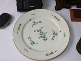 a white plate with blue flowers on it next to a cell phone