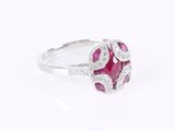 a close up view of a ruby and diamond ring on a white background