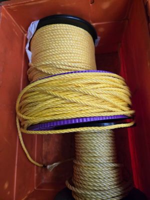 un gros plan sur une corde jaune dans une boîte ornée d'un ruban violet